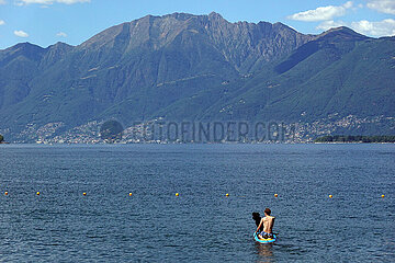 Locarno  Schweiz  Jugendlicher faehrt mit seinem Hund auf einem SUP-Board ueber den Lago Maggiore