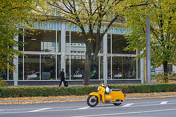 Berlin  Deutschland - Pavillion in der Karl-Marx-Allee mit parkender gelber Schwalbe