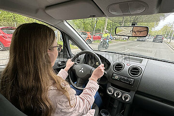 Berlin  Deutschland  junge Frau beim Autofahren in der Stadt