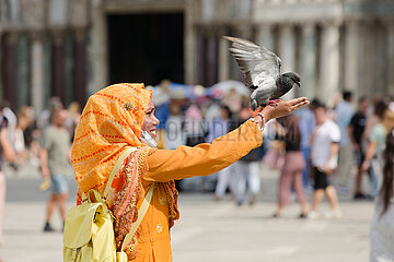 Venedig  Venetien  Italien  ITA - Am San Marco Platz haelt eine Frau eine Taube auf der Hand