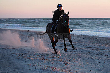 Dierhagen  Maedchen reitet am Abend auf ihrem Pferd am Strand der Ostsee
