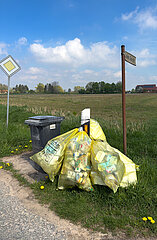 Deutschland  Ahsen-Oetzen - Gelbe Saecke und Muelltonne an Landstrasse